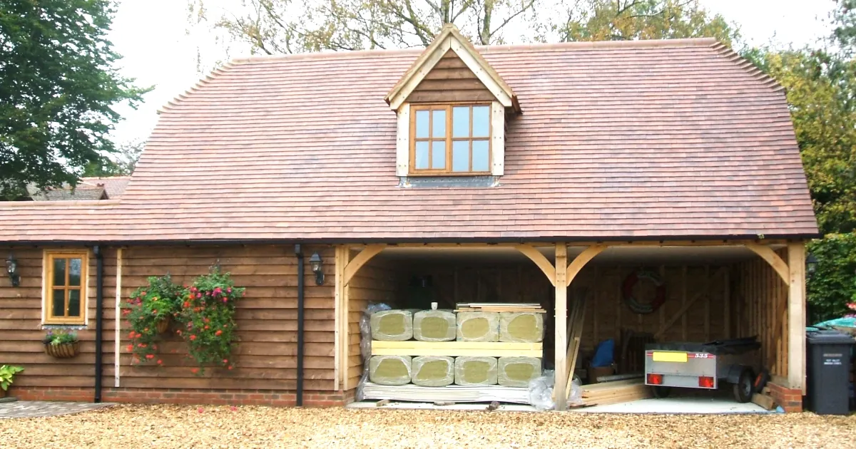 Insulating your oak framed building: a wooden oak framed building with insulation materials stacked in the open garage area