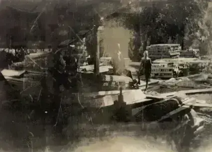 Black and white photo of holmsley sawmills, circa 1933, showcasing workers, machinery, and stacks of freshly cut timber.