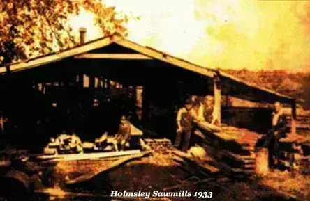 Sepia-toned photograph of holmsley sawmills in 1933, with workers handling oak logs for building construction.