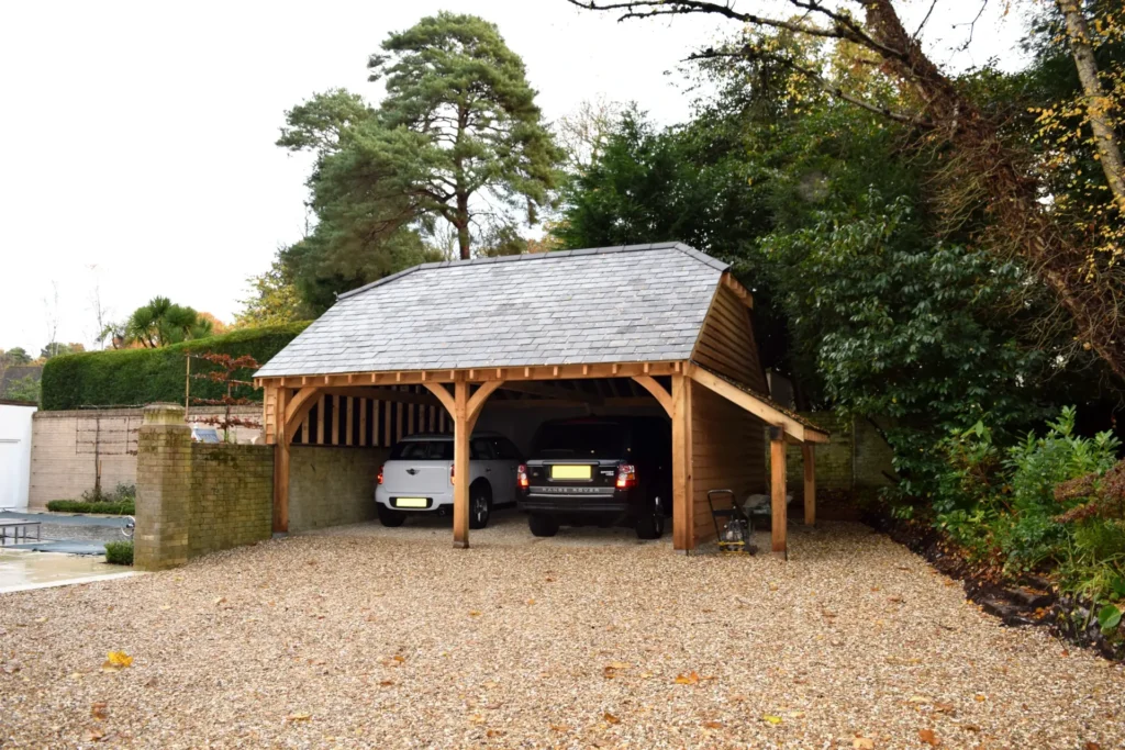 Traditional two bay open oak garage with exposed beams and slate roof, crafted by oakcraft.