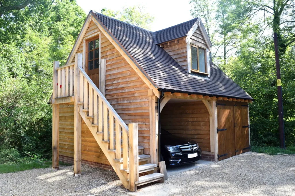 Oakcraft oak framed two bay garage with a room above, accessed by an external wooden staircase.