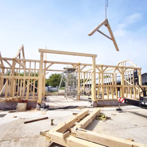 Oakcraft oak framed barn construction site in guildford, surrey, featuring timber framing in progress.