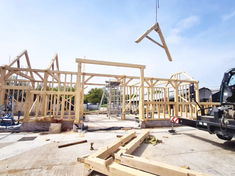 OakCraft oak framed barn construction site in Guildford, Surrey, featuring timber framing in progress.