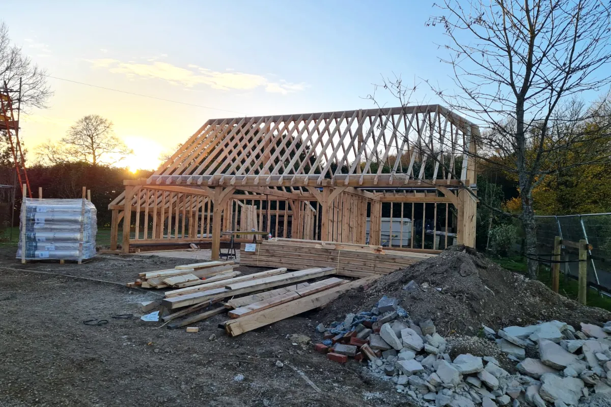 Oak framed 3-bay detached garage under construction at sunset in salisbury