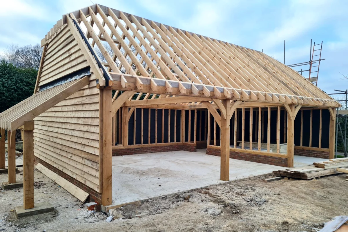 Three-bay oak framed garage under construction with visible timber framing and cladding in salisbury