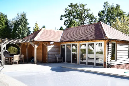 Bespoke garden pool house crafted by oakcraft, featuring generous float storage and summer entertaining space