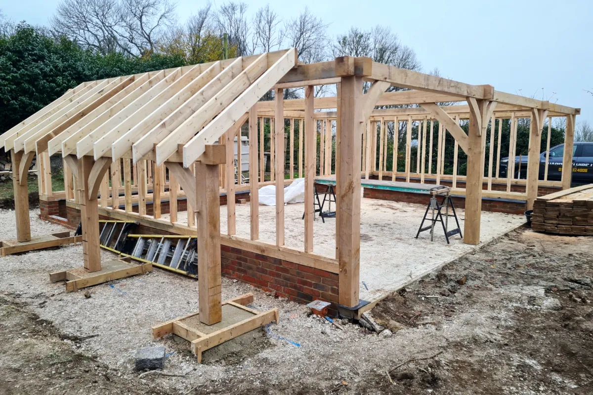 Oak framed 3-bay detached garage under construction in wiltshire with visible timber structure