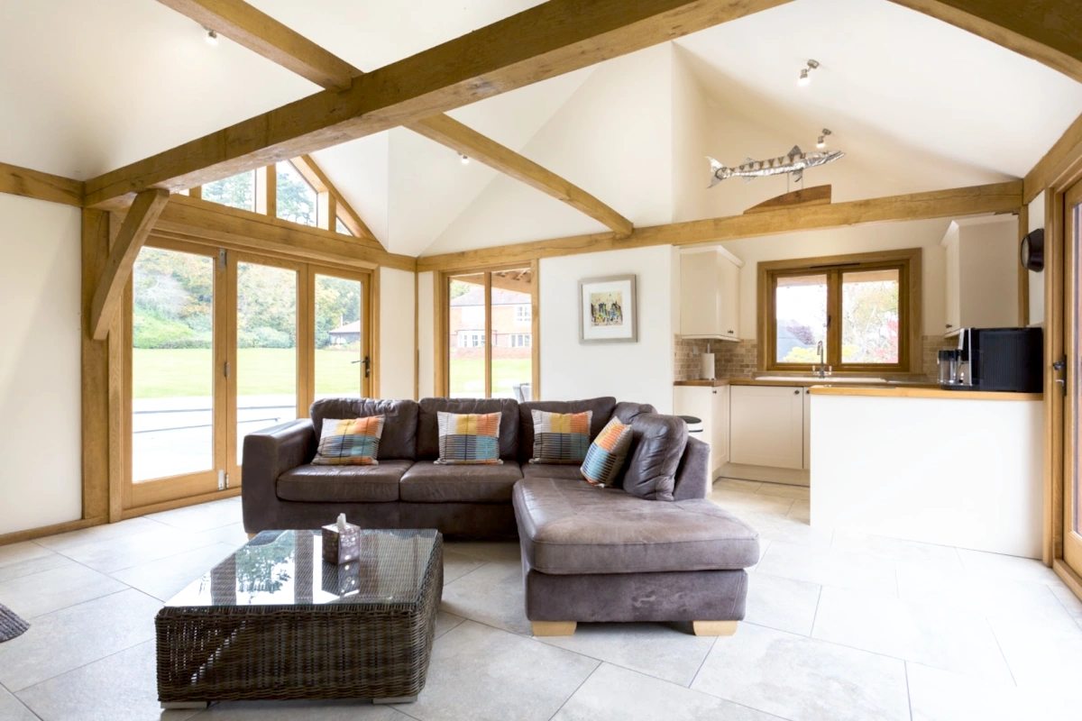 Oak frame construction pool house featuring exposed oak beams, vaulted ceiling, glazed gable end and open-plan design showing traditional timber frame craftsmanship