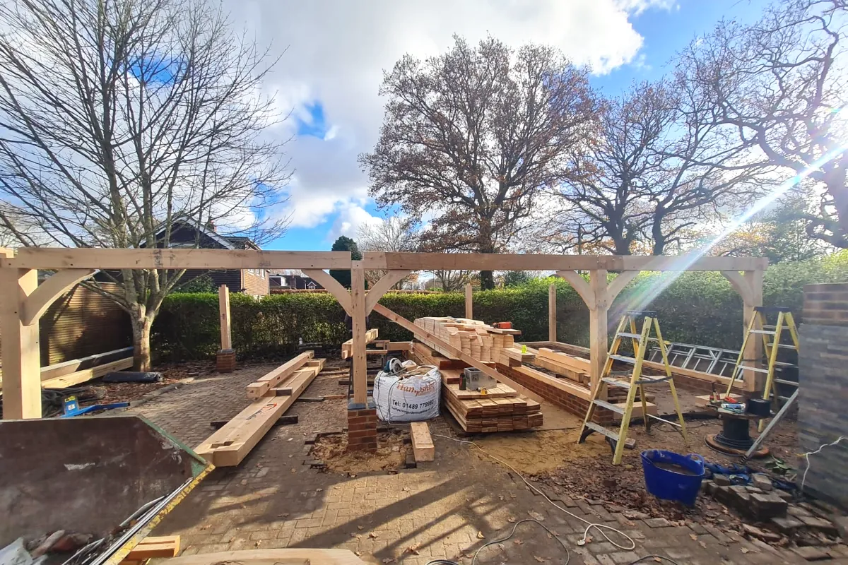 Construction progress of a triple bay oak frame garage in warsash, southampton, showing exposed oak posts and beams during installation by oakcraft