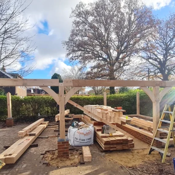 Construction progress of a triple bay oak frame garage in warsash, southampton, showing exposed oak posts and beams during installation by oakcraft