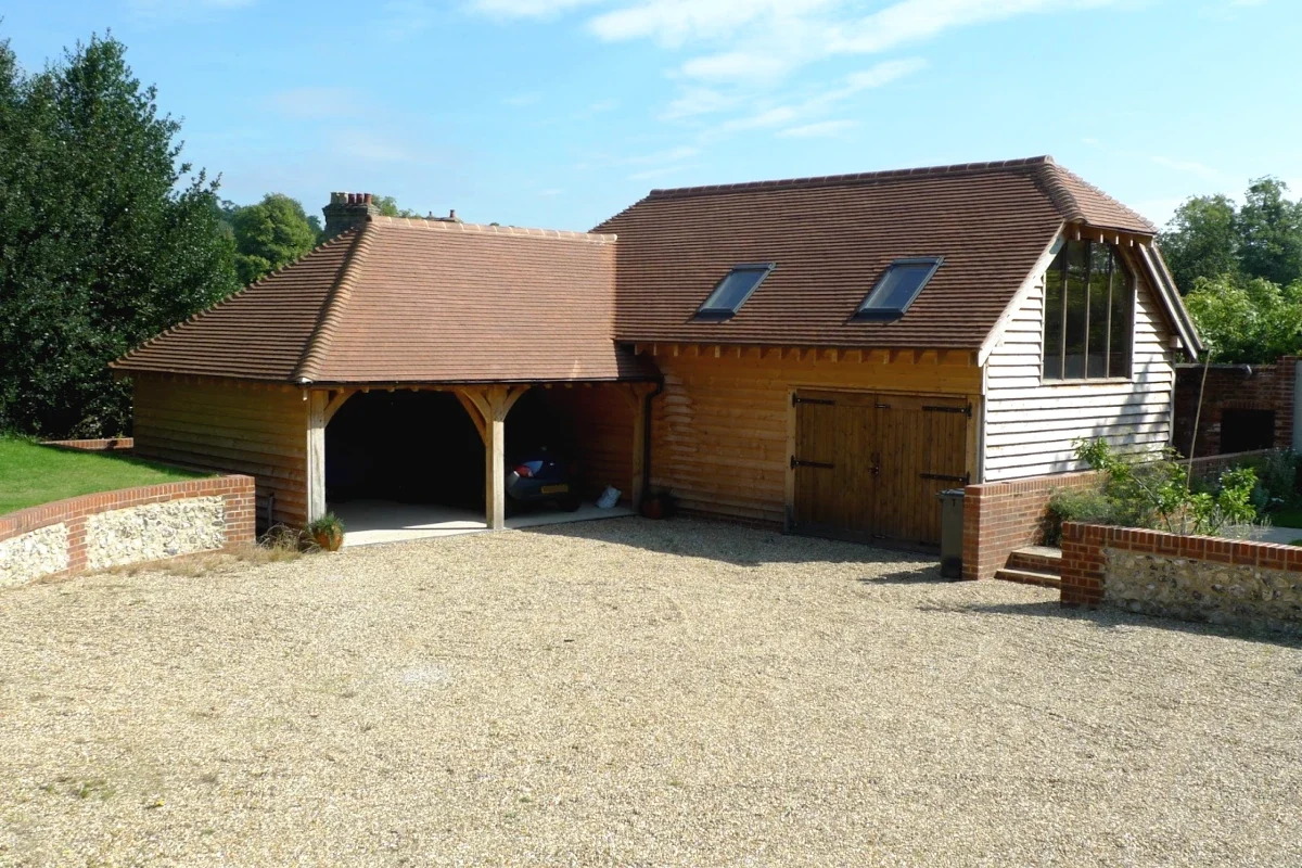 A beautiful oak outbuilding, this oak framed garage and carport combination, add both practical space and aesthetic appeal to this English home.