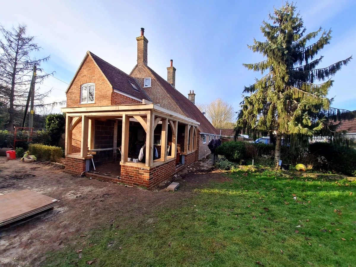 Oak framed orangery under construction showing brick base and oak posts in blashford, hampshire