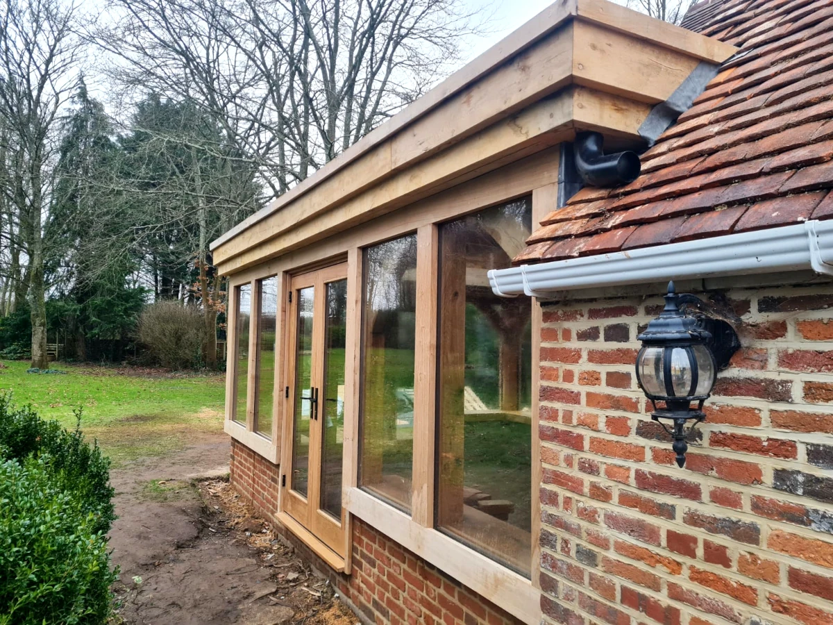 Bespoke oak framed orangery featuring french doors, direct glazing, and lantern roof, built in blashford, hampshire