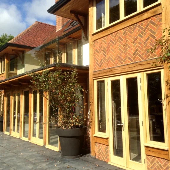 Modern oak framing used in this oak framed building with floor-to-ceiling glazing, decorative brickwork and clay tiled roof, built in hampshire