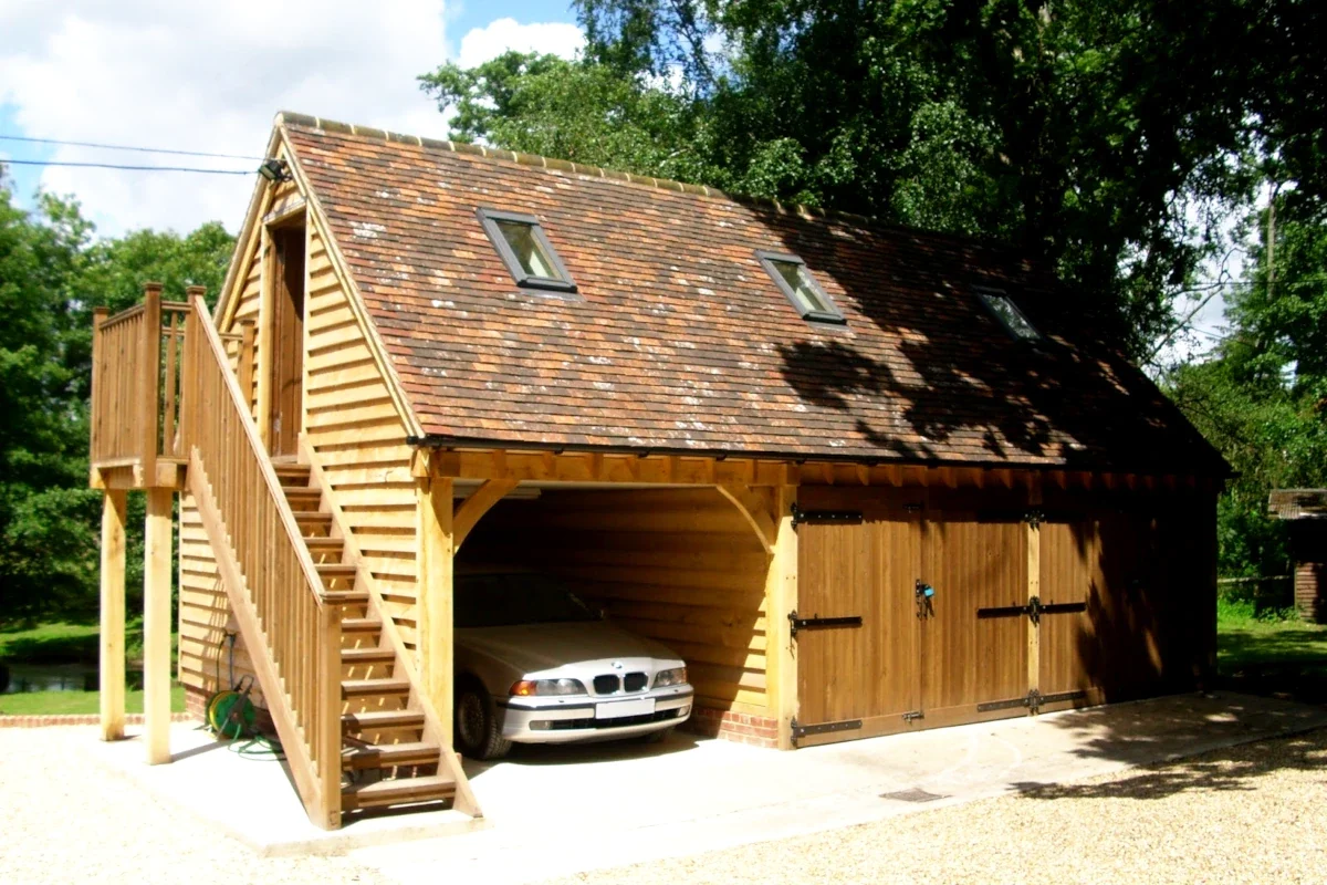 One of our traditional oak outbuildings, this oak framed garage with a loft space, provides secure parking and additional storage for an English property. The external staircase leads to a versatile loft area, perfect for a home office or workshop.