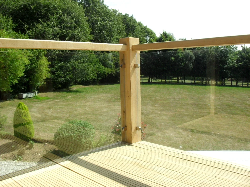 Oak Framed Balconies Fresh oak framed balcony with glass panels attached to black timber barn in rural Dorset featuring traditional curved braces and Purbeck stone steps
