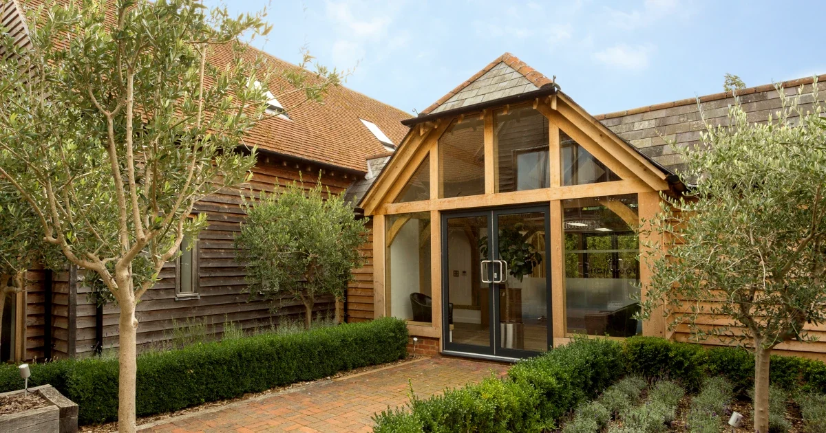 Bespoke Oak Framed Buildings In Hampshire Stunning bespoke oak framed buildings in Hampshire showcase: magnificent entrance featuring architectural glazed gable, handcrafted timber framework and traditional joinery techniques, exemplifying our master craftsmen's expertise in custom oak construction across Hampshire