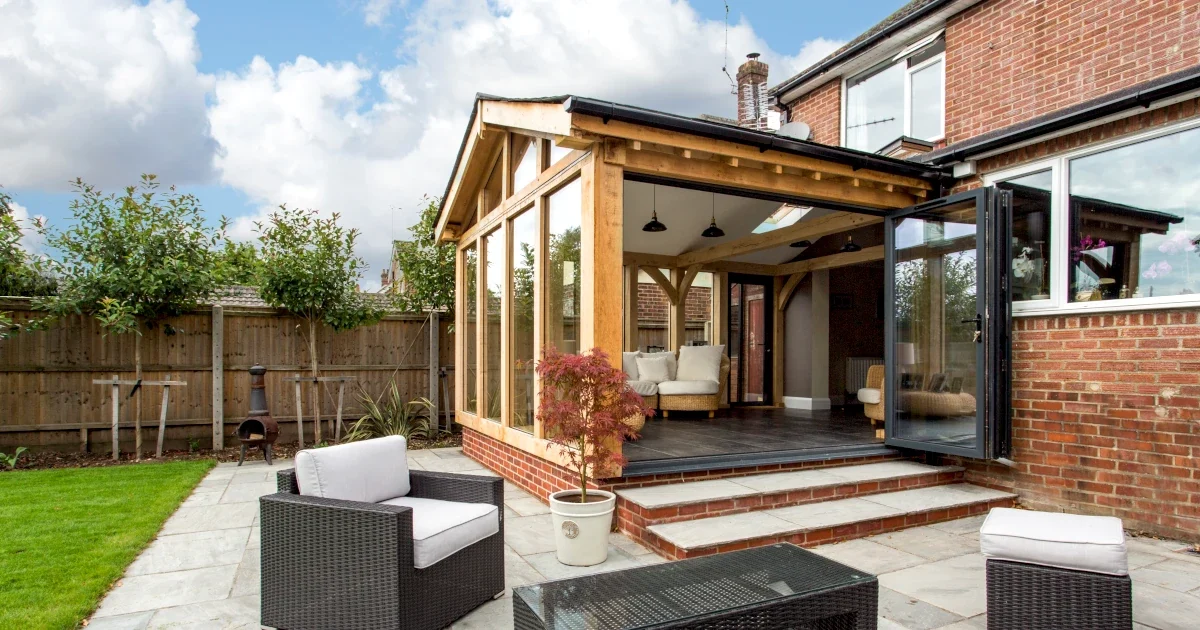 Oak Framed Extensions Hampshire Stunning oak framed extensions Hampshire project showcasing a vaulted ceiling design with bifold doors leading to a stone patio area and professionally landscaped garden, perfect for enhancing traditional and modern homes across Hampshire