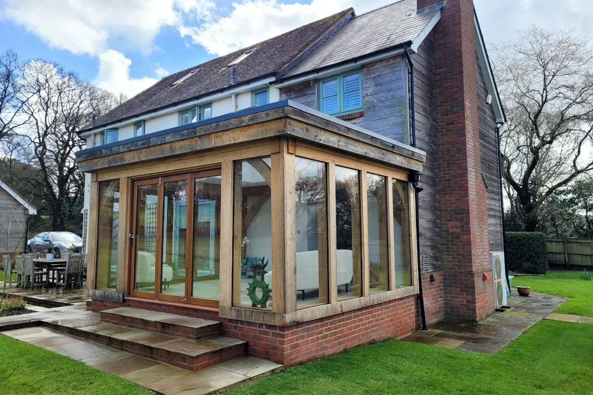 Traditional oak framed orangery extension with a brick base, UK garden